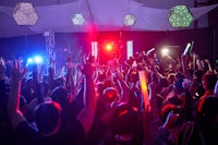 a crowd of people at a party with lights